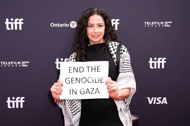 2025 Toronto International Film Festival - Palestine 36 TORONTO, CANADA - SEPTEMBER 5 : A guest, wearing keffiyeh, holds a banner reading End the Genocide in Gaza during the premiere of ‘Palestine 36’ during the 2025 Toronto International Film Festival at Roy Thomson Hall in Toronto, Ontario, Canada on September 5, 2025. Mert Alper Dervis Anadolu Ontario Canada. Editorial use only. Please get in touch for any other usage.  Copyright: x2025xAnadoluxMertxAlperxDervisx