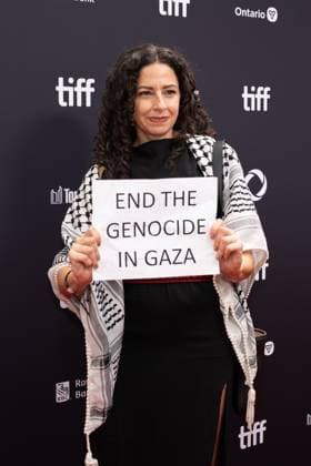 September 5, 2025, Toronto, Ontario, Canada: A guest holds a banner reading End the Genocide in Gaza during the red carpet for the Palestine 36 premiere during the 2025 Toronto International Film Festival at Roy Thomson Hall. on September 5, 2025 in Toronto, Canada. Toronto Canada - ZUMAe321 20250905_zea_e321_038 Copyright: xLeonardoxRamirezx