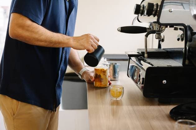 IMAGO Creative, Food, Trend, Iced Coffee PR_ID30758_11598_RandaStudio.jpg, MR_ID30758_22173_ClarenaSalamanca.jpg, MR_ID30758_22174_JorgeEnrriqueParrado.jpg, MR_ID30758_22175_LilianaAndreaLonga.jpg A man makes iced coffee in an office setting, using a modern coffee machine. This cozy setup inspires productivity and provides a refreshing break for coworkers and team members, Property released Model Released AngelaRober_ID30758_1041693_002 Copyright: xAngelaxRoberx