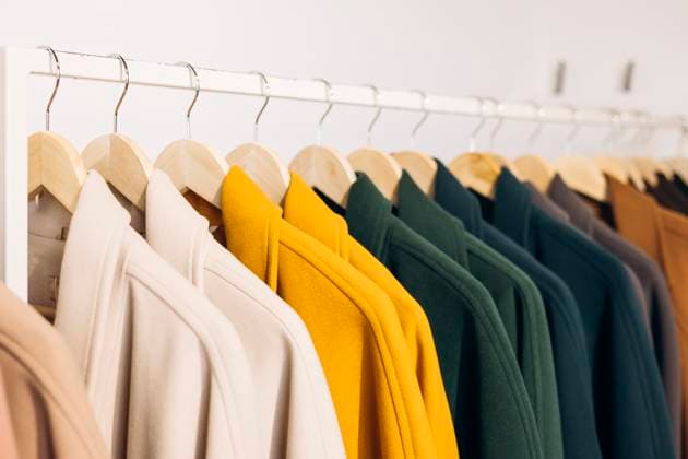 Colorful autumn coats on hangers in a store display A vibrant display of colorful autumn coats hanging neatly on wooden hangers in a store. Each coat showcases different warm shades, creating a cozy and inviting retail atmosphere. Model Released HannaYakimenko_ID31135_1056218_001 Copyright: xHannaxYakimenkox