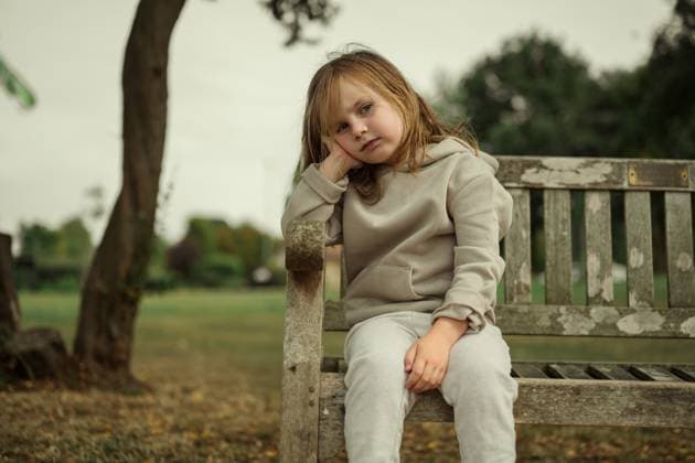 Creative Highlight Symbolbilder Bored, upset little girl sitting on a bench in the park Corby, England, United Kingdom CR_ATMT25090663-1815439-01 ,model released, Symbolfoto