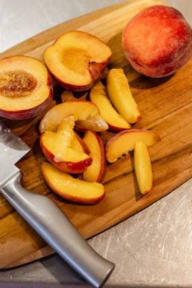 Freshly sliced peaches on a wooden cutting board Kelowna, British Columbia, Canada R_PESF2509050A-1816831-01