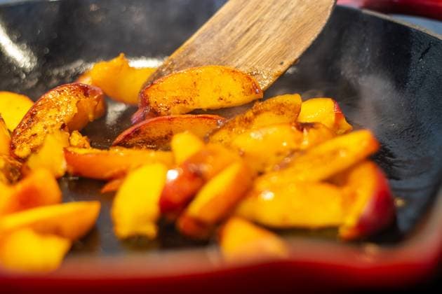 Caramelizing peach slices in a hot skillet with steam rising Kelowna, British Columbia, Canada R_PESF2509050A-1816836-01
