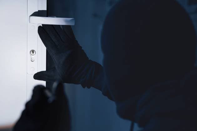 Robber in black balaclava cracking door with metal picklock Break-In Concept. Back view of unrecognizable criminal in black balaclava entering victim s house, using torch on lock, model released, , 94828706.jpg RECORD DATE NOT STATED