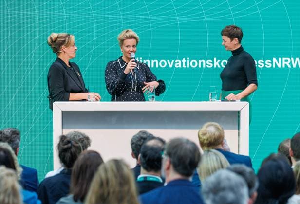 08.09.2025. Düsseldorf. Mit dem Innovationspreis NRW 2025 zeichnet das Land engagierte Persönlichkeiten aus, die mit Kreativität, Einsatz und Risikobereitschaft maßgeblich zur Innovationsstärke Nordrhein-Westfalens beitragen. NRW-Wirtschafts- und Klimaschutzministerin Mona Neubaur verleiht den Preis an Forscher aus Düsseldorf und Bielefeld. Hier v. li.: NRW-Wirtschafts- und Klimaschutzministerin Mona Neubaur, NRW-Wissenschaftsministerin Ina Brandes und Moderatorin Kimsy von Reischach. Düsseldorf EUREF-Campus Nordrhein-Westfalen Deutschland