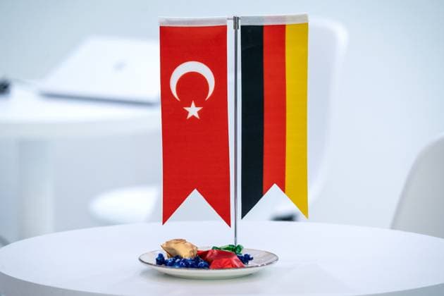 Die Fahnen von Deutschland und der Türkei nebeneinander auf einem Tisch symbolisieren Partnerschaft, Zusammenarbeit und Freundschaft zwischen beiden Ländern