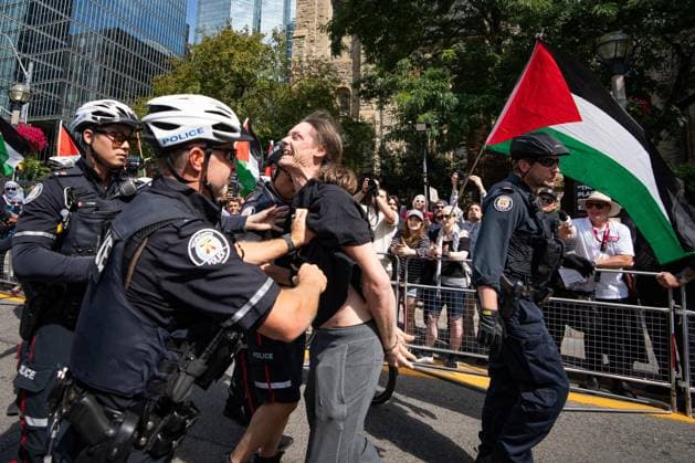 September 10, 2025, Toronto, On, Canada: Toronto Police arrest a man as protesters and counter-protesters gather outside of Roy Thomson Hall during the screening of the documentary The Road Between Us: The Ultimate Rescue at the Toronto International Film Festival in Toronto on Wednesday, Sept. 10, 2025. Toronto Canada  - ZUMAc35_ 20250910_zaf_c35_064 Copyright: xArlynxMcadoreyx
