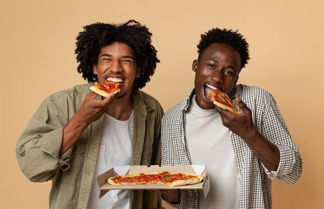 Tasty Snack. Two Hugry Black Guys Eating Italian Pizza From Box Tasty Snack. Two Hugry Black Guys Eating Italian Pizza From Box And Looking At Camera, Cheerful African American Male Friends Enjoying Food Delivery Service, Standing On Beige Background, Free Space, model released, , 96584400.jpg RECORD DATE NOT STATED