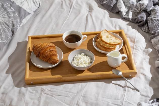 Delicious breakfast tray with croissant, bread, coffee, and cottage cheese set on a cozy bed in natural morning light Delicious breakfast tray with croissant, bread, coffee, and cottage cheese set on a cozy bed in natural morning light., 97024526.jpg RECORD DATE NOT STATED