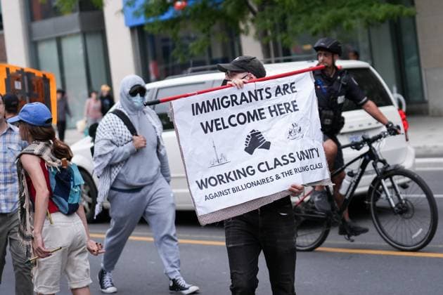 Anti-immigration rally and counter-demonstration in Toronto TORONTO, CANADA - SEPTEMBER 13 : Counter-protestors hold a sign while protestors walk during anti-immigration rally in Toronto, Ontario on September 13, 2025. Mert Alper Dervis Anadolu TORONTO Canada. Editorial use only. Please get in touch for any other usage.  Copyright: x2025xAnadoluxMertxAlperxDervisx