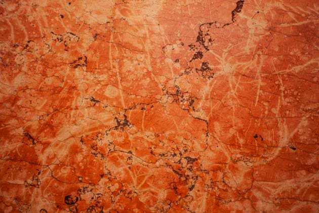 Red marble surface showing intricate veins and patterns in bologna, italy Bologna, Italy 1 January 2025: Close-up view of a polished red marble surface, highlighting natural patterns and textures, ideal for backgrounds and design projects, 64092392.jpg RECORD DATE NOT STATED