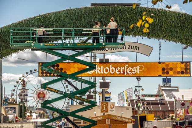 In fünf Tagen startet das Oktoberfest 2025: letzte Dekoarbeiten am Haupteingang, München, 15. September 2025 Deutschland, München, 15. September 2025, letzte Arbeiten am Haupteingang zur Wiesn, Mitarbeiter auf einer Arbeitsbühne dekorieren den Torbogen, schmücken das Portal mit grünen Tannenzweigen, durch diesen Eingang strömen ab Samstag dtäglich Tausende Wiesnbesucher, Schild Willkommen zum Oktoberfest, Baustelle, die Festzelte und Fahrgeschäfte stehen schon und es werden auf der Theresienwiese hauptsächlich letzte Feinarbeiten durchgeführt, Symbolfoto: in fünf Tagen startet das Oktoberfest 2025, Herbst, schönes Wetter, blauer Himmel, Bayern, bayerisch, *** Oktoberfest 2025 starts in five days, final decoration work at the m