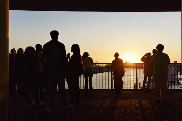 Menschenmenge genießt Ausblick von der Elbphilharmonie über die Elbe bei Sonnenuntergang, Silhouetten, Aussichtsplattform Plaza, Hamburg, Deutschland Crowd enjoying the view from the Elbphilharmonie over the Elbe at sunset, silhouettes, Plaza viewing platform, Hamburg, Germany Copyright: imageBROKER AngelaxtoxRoxel iblato15101229.jpg