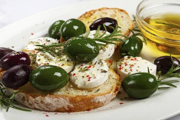 Ein Teller mit einem Snack, Ciabatta Brot mit Käse und Oliven, Olivenöl, Gewürzen und Kräutern, Blick von oben, keine Menschen A plate with a snack, ciabatta bread with cheese and olives, olive oil, spices and herbs, top view, no people Copyright: imageBROKER Didebashvili ibxgai15091221.jpg