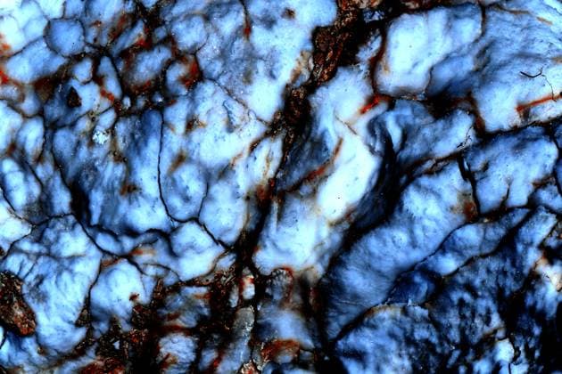 Blurred white blue marble stone surface with red veins cracks a hard crystalline metamorphic form of limestone, typically white with mottling or streaks of color,, 98045968.jpg RECORD DATE NOT STATED