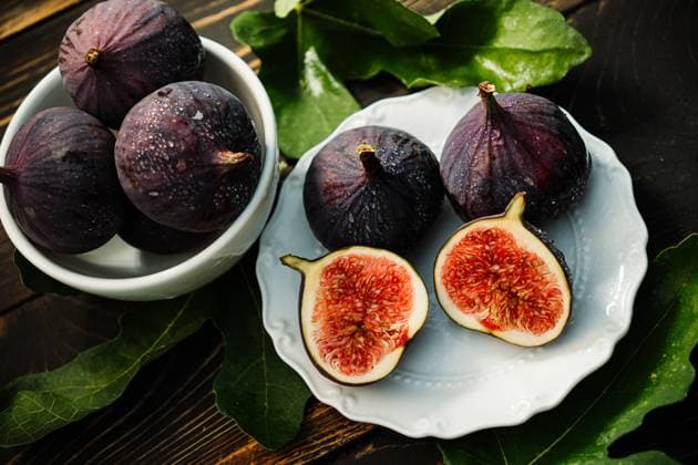Delicate Fresh Ripe Figs With Leaves On White Plate, Rustic Wooden Table. Ficus Delicate fresh ripe figs with leaves on white plate, rustic wooden table. Ficus carica. Beautiful sweet seasonal fruits, vegan food. Top view. High quality photo, 96035508.jpg RECORD DATE NOT STATED
