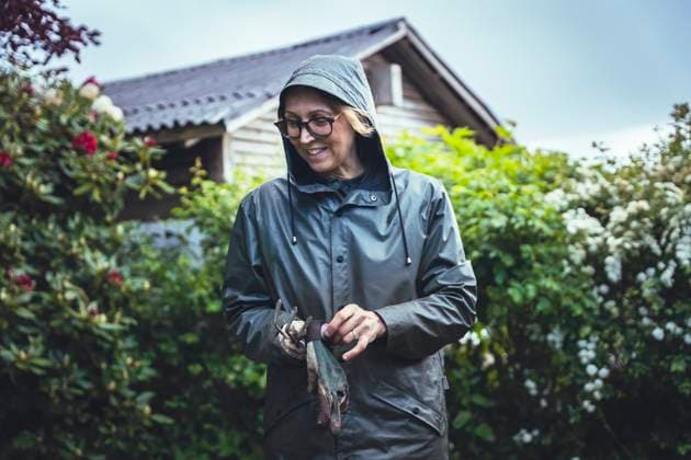 IMAGO Creative, Jahreszeit Sommer, Regen, Sommerregen Woman With Gardening Gloves Surrounded By Lush Nature Haarby, Denmark CR_EMWIXA250917-1832601-01 ,model released, Symbolfoto