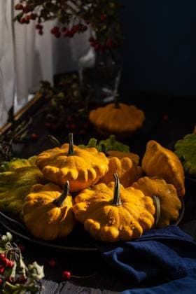 IMAGO Creative, Jahreszeit Herbst auf dem Land Fresh yellow pattypan squash with water droplets on dark background Ripe pattypan squash with water droplets, creating a visually appealing scene with natural light and dark background, 94709650.jpg RECORD DATE NOT STATED