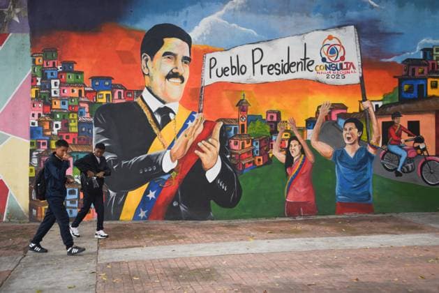 (250922) -- CARACAS, Sept. 22, 2025 -- Men pass in front of a mural for President Nicolas Maduro in Caracas, Venezuela, on Sept. 22, 2025. (Photo by Xinhua) VENEZUELA-CARACAS-STREET MarcosxSalgado 