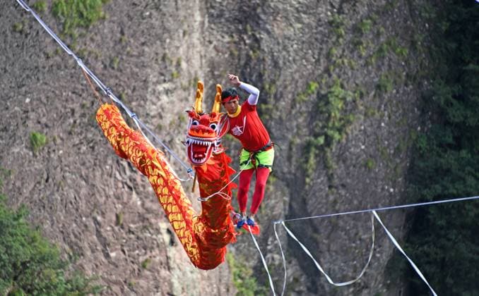 TAIZHOU, CHINA - SEPTEMBER 22: A slackline walker performs dragon dance at Shenxianju scenic area on September 22, 2025 in Taizhou, Zhejiang Province of China. The 2025 Shenxianju Cup China International Slackline Open is being held from Saturday to Tuesday at the scenic area.  Copyright: xVCGx 111592550269