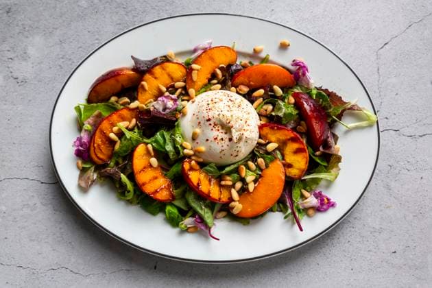 Grilled nectarine and burrata salad with pine nuts and edible flowers, SARF04684