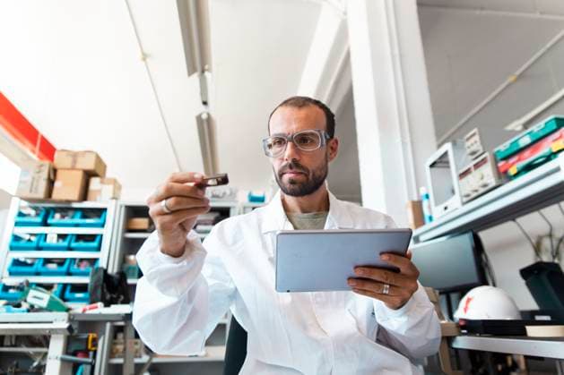 Lab technician analyzing microchip with tablet in electronics workshop model released, Symbolfoto property released, PCLF02695