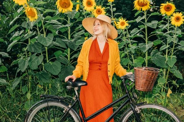 Vintage style woman outdoors with bicycle in sunflower garden model released, Symbolfoto, VSNF04142