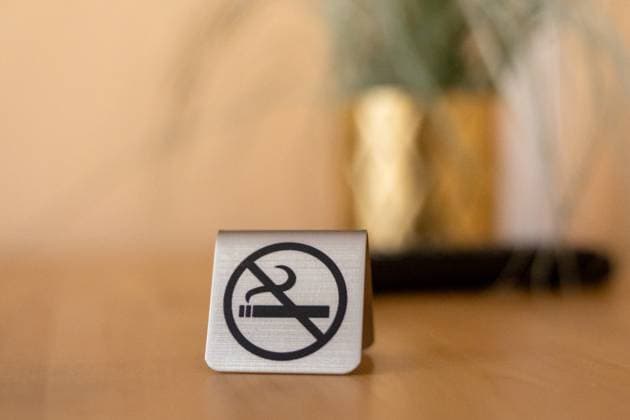 Germany - September 20, 2025: A small sign with the symbol for no smoking stands on a table and makes it clear that smoking is not allowed here and that there is a non-smoking area *** Ein kleines Schild mit dem Symbol für Rauchverbot steht auf einem Tisch und macht deutlich, dass Rauchen hier nicht erlaubt ist und ein Nichtraucherbereich besteht