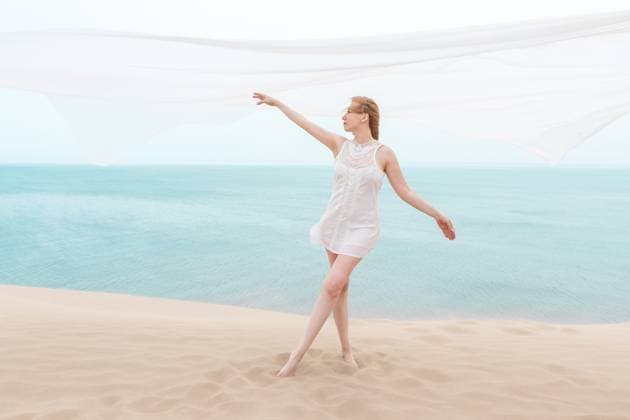 MR_ID31405_22663_ElenaKobzar.jpg Elegant young woman in a flowing white dress gracefully dancing on a sandy beach. The fabric moves with the wind, embodying summer s freedom and beauty with minimalistic elegance Model Released SvetlanaRadayeva_ID31405_1068103_001 Copyright: xSvetlanaxRadayevax