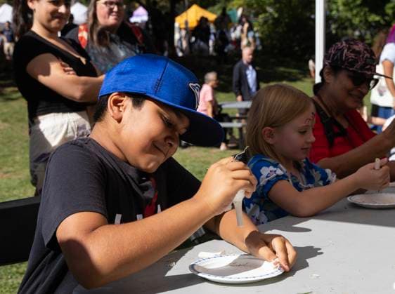 (250929) -- TORONTO, Sept. 29, 2025 -- A boy (L) participates in a garlic bulb cracking contest during the 14th Toronto Garlic Festival in Toronto, Canada, on Sept. 28, 2025. The annual festival was held here on Sunday to celebrate garlic s diverse culinary and cultural uses, with many visitors in attendance. (Photo by Xinhua) CANADA-TORONTO-GARLIC FESTIVAL ZouxZheng 