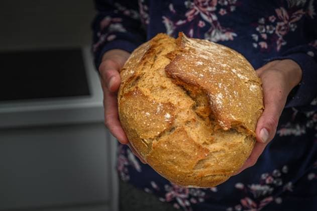 Homemade sourdough bread. Bright white kitchen.1 Female hand holding hot freshly baked bread 1, 60559816.jpg RECORD DATE NOT STATED