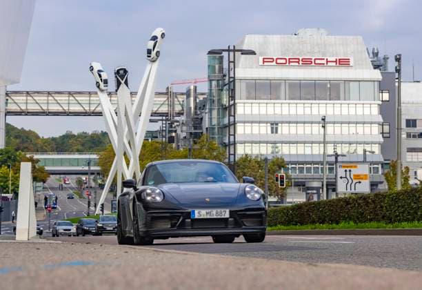 Porscheplatz, Stuttgart Zuffenhausen mit Porsche Hauptverwaltung. Kunstwerk Inspiration 911 von Gerry Judah: drei Stelen, die in bis zu 24 Metern Höhe je einen Porsche 911 präsentieren. Autotransporter mit Neuwagen. 29.09.2025: Stuttgart, Baden-Württemberg, Deutschland *** Porscheplatz, Stuttgart Zuffenhausen with Porsche headquarters Artwork Inspiration 911 by Gerry Judah Three steles, each up to 24 meters high, each presenting a Porsche 911 Car transporter with new cars 29 09 2025 Stuttgart, Baden Württemberg, Germany