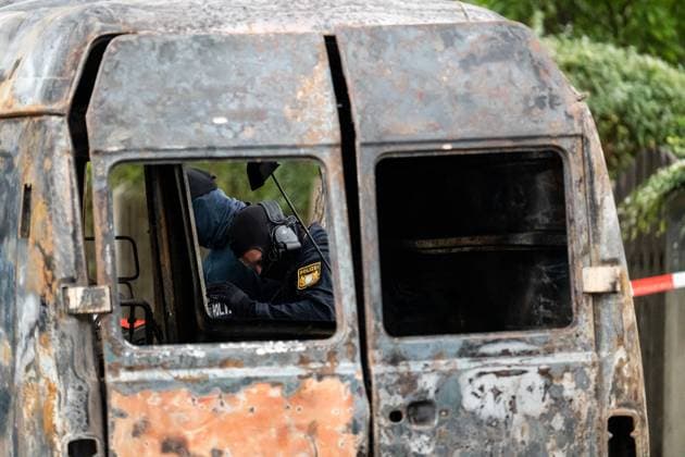 Munich, Bavaria, Germany - October 1, 2025: Several explosions shake Munich-Lerchenau. Police and special forces deployed on a large scale, houses evacuated. Police officers from a special unit examine the burnt-out van *** Mehrere Explosionen erschüttern Münchn-Lerchenau. Polizei und Spezialkräfte im Großeinsatz, Häuser wurden evakuiert. Polizisten einer Spezialeinheit untersuchen den abgebrannten bzw. ausgebrannten Transporter