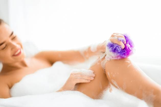 Happy woman washing leg with sponge in bath with foam Happy woman washing leg with sponge in bath with foam, relaxing in bathtub, model released, , 60769726.jpg RECORD DATE NOT STATED