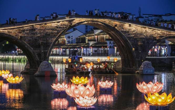 (251003) -- HANGZHOU, Oct. 3, 2025 -- Tourists visit Tangqi ancient town in Hangzhou, east China s Zhejiang Province, Oct. 2, 2025. The town offers tourists night boat tours and dazzling lanterns during the eight-day National Day and Mid-Autumn Festival holiday that began on Wednesday. ) CHINA-ZHEJIANG-HANGZHOU-NIGHT TOUR (CN) XuxYu 