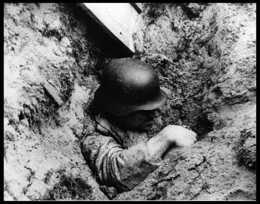 Debarquement en Normandie du 6 juin 1944 (Jour J ou D Day) : un soldat allemand s extirpe de sa tranchee apres qu un obus l ait faite s ecrouler. Photographie prise sur une plage de Normandie, 6 juin 1944. RECORD DATE NOT STATED *** Normandy landings, June 6, 1944 D-Day a German soldier pulls himself out of his trench after a shell has caused it to collapse Photograph taken on a Normandy beach, June 6, 1944 RECORD DATE NOT STATED  Copyright: x usis-dite opale.photox