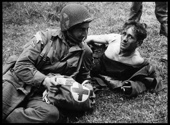 Deuxieme guerre mondiale (1939-1945) : au Poste de secours de la 307th Airborne Medical Company de la 82nd US AB installe dans une ferme pres de Sainte Mere Eglise (Sainte-Mere-Eglise), un caporal infirmier en compagnie d un soldat allemand blesse. Normandie, France, photographie prise quelques jours apres le debarquement du 6 Juin 1944. RECORD DATE NOT STATED *** World War II 1939 1945 at the Aid Post of the 307th Airborne Medical Company of the 82nd US AB set up in a farmhouse near Sainte Mere Eglise Sainte Mere Eglise, a corporal nurse with a wounded German soldier Normandy, France, photograph taken a few days after D-Day on June 6, 1944 RECORD DATE NOT STATED  Copyright: x usis-dite opale.photox