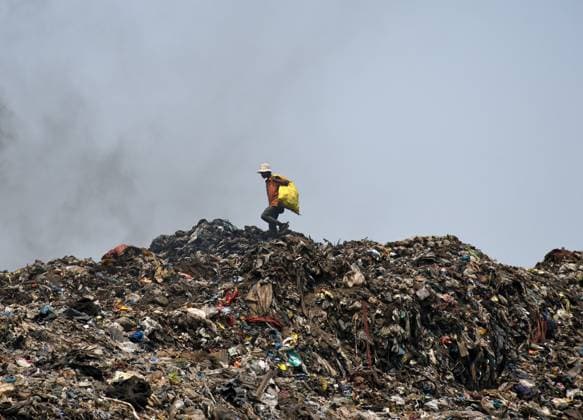 Garbage dumping ground in Mumbai, India - 22 Apr 2022 April 22, 2022, Mumbai, Maharashtra, India: A man walks on a heap of garbage at a dumping ground during Earth Day on the outskirts of Mumbai. Earth Day is celebrated annually on 22nd April to create awareness about the environment and to preserve and protect our natural resources in all best possible ways. Copyright: xAshishxVaishnavx