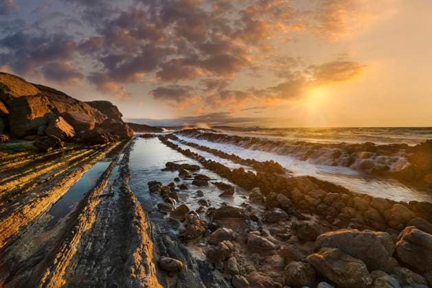 Creative Highlights World Sunset Over Rocky Coastal Landscape Santander, Cantabria, Spain CR_FRZA251005-1849588-01