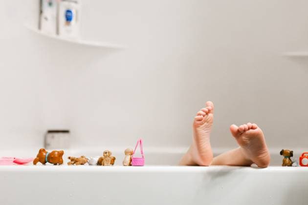Child s feet on bathtub ledge surrounded by bath toys McClure, Illinois, United States CR_WEKW251005B-1848635-01 ,model released, Symbolfoto