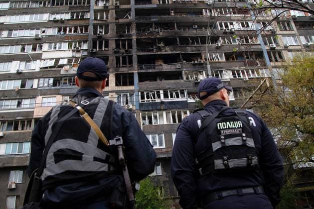 Police officers look at an apartment block that caught fire due to falling Russian drone debris in the Pecherskyi district of Kyiv, Ukraine, October 10, 2025. At least nine people were injured in Kyiv during an overnight Russian missile and drone attack. The Pecherskyi district is the most affected as debris caused a fire in a high-rise building. Rescuers evacuated 20 residents and handed five people over to medics. (Photo by Kirill Chubotin Ukrinform) Apartment block in Kyiv’s Pecherskyi district catches fire due to Russian strike  Copyright: xKirillxChubotinx
