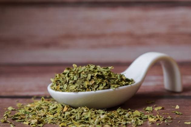 Getrocknete Moringa-Oleifera-Blätter, die einen weißen Porzellanlöffel auf einem Holztisch füllen Getrocknete Moringa-Oleifera-Blätter, die einen weißen Porzellanlöffel auf einem Holztisch füllen (License=RF) Copyright: xZoonar.com josexmariaxhernandezxantonax 24005559