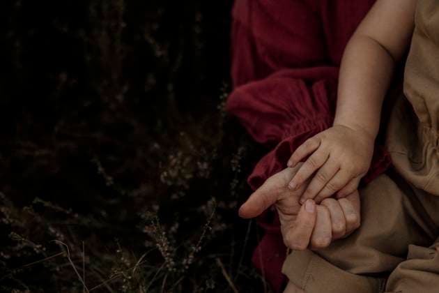 Toddler and mother holding hands in tall heather grass Amsterdam, North Holland, Netherlands R_RTBZ251008-1855813-01