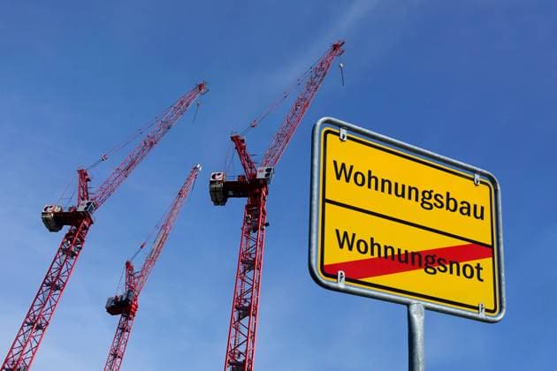 Baukräne und Ortsschild mit Schriftzüge Wohnungsbau sowie Wohnungsnot Fotomontage: Baukräne und Ortsschild mit Schriftzüge Wohnungsbau sowie Wohnungsnot, 13.10.2025, Neben mehreren Baukränen befindet sich ein Ortsschild mit den Schriftzügen Wohnungsbau sowie Wohnungsnot. *** Construction cranes and town sign with the words Wohnungsbau and Wohnungsnot Photomontage Construction cranes and town sign with the words Wohnungsbau and Wohnungsnot, 13 10 2025, Next to several construction cranes is a town sign with the words Wohnungsbau and Wohnungsnot