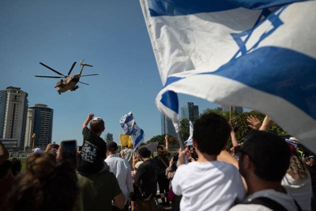 (251013) -- PETAH TIKVA, Oct. 13, 2025 -- People celebrate as the helicopter carrying released hostages arrives at a hospital in Petah Tikva, Israel, Oct. 13, 2025. The Israeli military announced on Monday that all remaining living hostages held by Hamas in Gaza are now in Israel, as the country began releasing Palestinian prisoners. The military said in a statement that the final group of 13 hostages had crossed the border into Israeli territory. Earlier in the day, the first group of seven hostages returned to Israel after over two years of captivity in the Gaza Strip. ) ISRAEL-PETAH TIKVA-HAMAS-HOSTAGES-ARRIVAL ChenxJunqing 