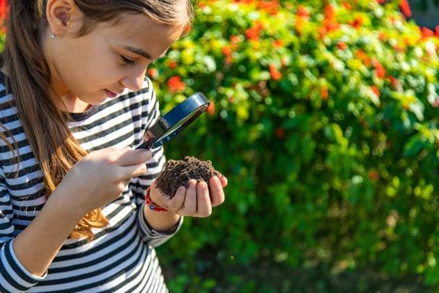 Children examine the soil with a magnifying glass. Selective focus. Children examine the soil with a magnifying glass. Selective focus. Kid., model released, , 59805552.jpg RECORD DATE NOT STATED