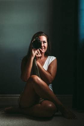 Woman photographer in dark room looking through camera. Kingston, Ontario, Canada CR_DOHO251008H-1849566-01 ,model released, Symbolfoto