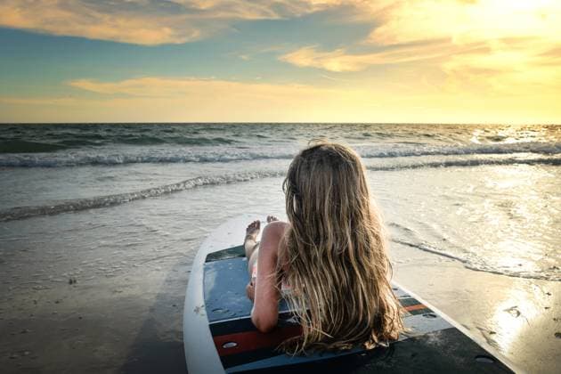 Behind young girl sitting on paddle board at sunset Gulf of Mexi Anna Maria, Florida, United States CR_JOKU251013A-1843985-01 ,model released, Symbolfoto