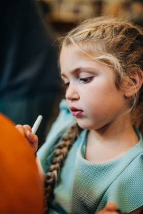 Young girl drawing face on halloween pumpkin North Andover, Massachusetts, United States CR_FKNH251013-1849653-01 ,model released, Symbolfoto