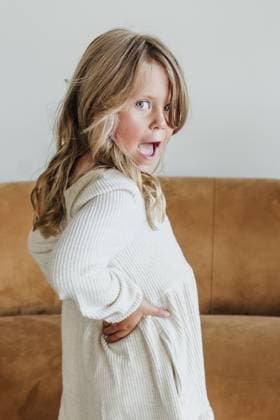 Young girl wearing dress poses by camel colored couch in studio Sioux Falls, South Dakota, United States R_ASWE251008-1830911-01 ,model released, Symbolfoto